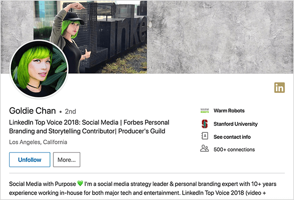 Ez egy képernyőkép Goldie Chan LinkedIn profiljáról. Zöld hajú ázsiai nő. Profilfotóján smink, fekete choker nyaklánc és fekete inget visel. Taglista szerint „LinkedIn Top Voice 2018: Social Media | Forbes személyes márkaépítés és történetmesélés közreműködő | Producer’s Guild ”