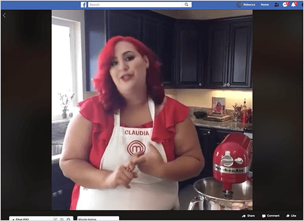 Ez egy képernyőkép a Facebook Live videóról, amelyben Claudia Sandoval séf szerepel, amelyet 2016-ban a T-Mobile keddek alkalmazással folytatott kereszt-promóció keretében szervezett. A videóban Claudia egy konyhában áll, fekete szekrénnyel és gránit munkalapokkal. A mosogató fölött lévő ablak természetes fényt enged be a szobába. Claudia egy piros Kitchen Aid keverő mellett áll. Latin nő, élénkvörös haja van, amely éppen a válla alá esik. Sminket visel, élénkpiros felsőt és fehér kötényt, vörös cérnával hímezve Claudiát és a MasterChef logót. Miközben beszél, intett a kezével. 2016-ban Stephanie Liu együttműködött Claudiával, hogy elkészítse ezt az élő videót.