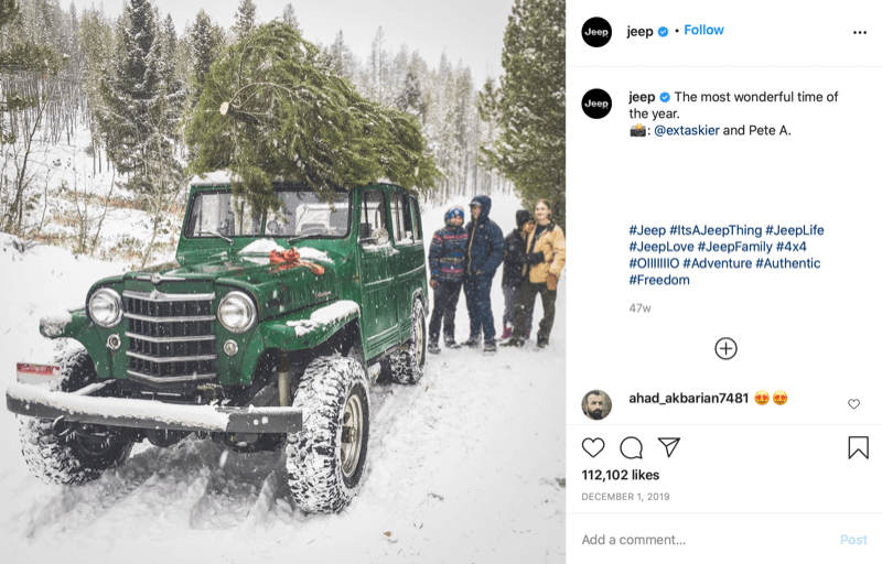 Instagram bejegyzés a @jeep-ről, ahol egy család látható a karácsonyfa végén vadászva egy fával a dzsipjük tetején, mélyen a hóban és a fák országában