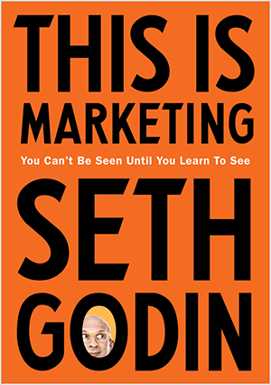 Ez egy képernyőkép a Seth Godin This Is Marketing borítójáról. A borító függőleges téglalap, narancssárga háttérrel és fekete szöveggel. Seth fejének fényképe megjelenik a vezetéknevének O-jában.